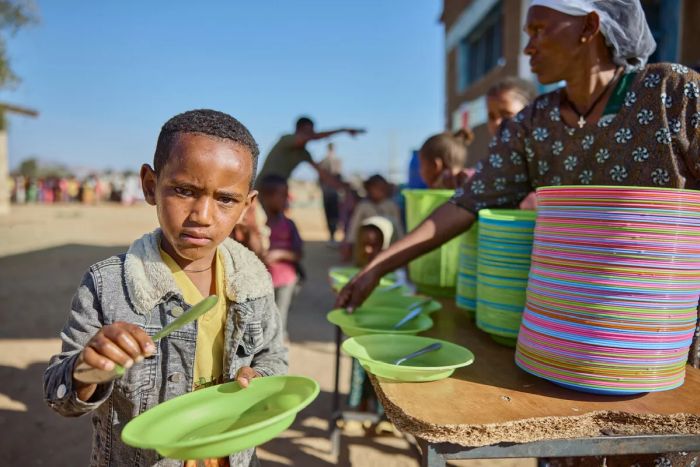 En pojke på väg att serveras en måltid på Tsehafe Werdi Primary School i Tigray, Etiopien, i mars 2024.