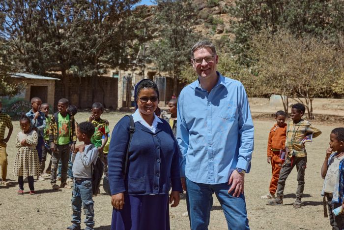 Mary's Meals grundare Magnus MacFarlane Barrow är här avbildad med dottern till välgörenhetssyster Medhin Tesfay under sitt besök i Tigray i mars 2024