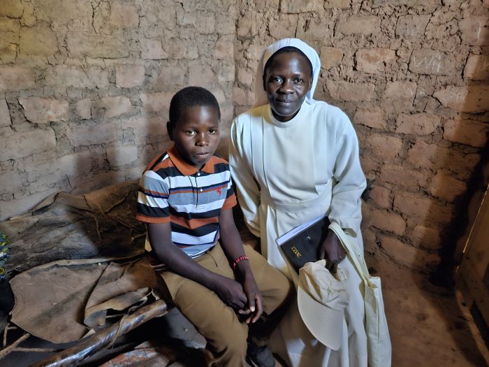 Syster till Mary Asella Kokugonza Ernest, som är född i Tanzania, sitter bredvid Aneck i hans hem. Aneck hade precis klarat provet och är nu student på Boystown