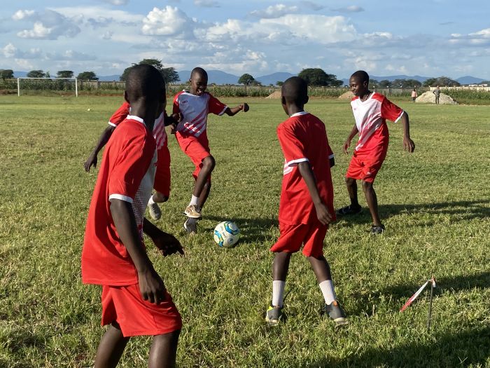Tonårspojkar njuter av den populära sporten Tanzania på Boystown-planen utanför Dodoma, Tanzania. En Boystown-student från Filippinerna fortsatte att spela i VM och blev en av de bästa spelarna i landets historia.