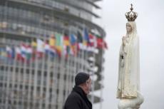 En präst står nära en staty av Jungfru Maria som har placerats framför Europaparlamentets byggnad kvällen före påven Franciskus besök i Europaparlamentet och Europarådet i Strasbourg