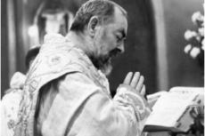 St. Padre Pio ber medan han firar mässan
