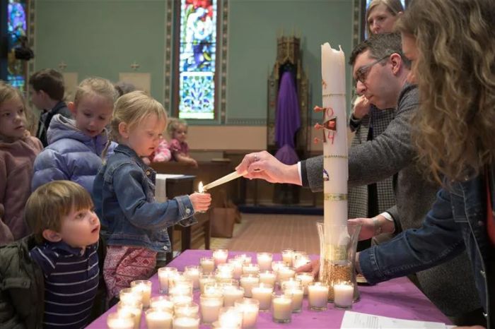 Föräldrar hjälper barnen att tända ljus vid en "Ljusets liturgi för barn" som firas på palmsöndagen i Mount Calvary Catholic Church i Baltimore