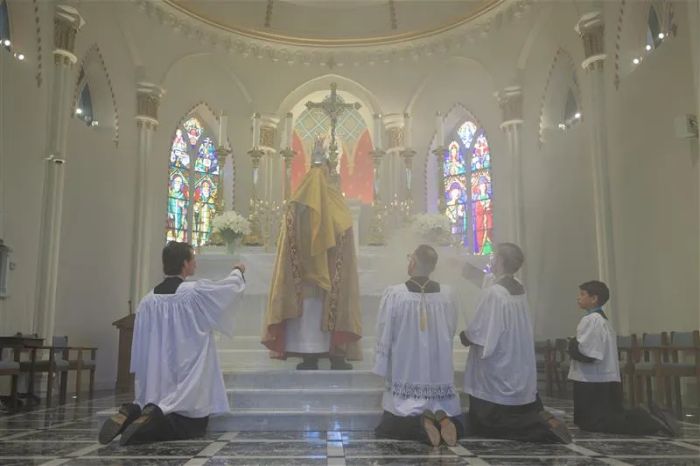 Fader Albert Scharbach, pastor i Mount Calvary Catholic Church i Baltimore, höjer den heliga eukaristin på högtiden Corpus Christi