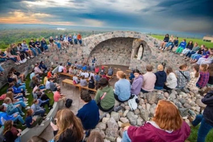 Studenter vid University of Mary samlas för att fira den välsignade Moderns födelsedag i skolans grotta.