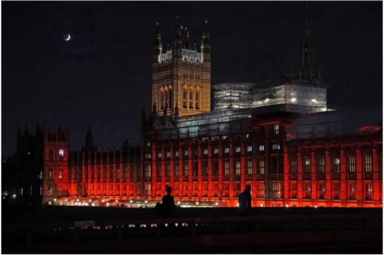 Houses of Parliament i Westminster är upplyst i rött ljus för att markera #RedWednesday