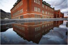 Den tidigare Kamloops Indian Residential School återspeglas i en vattenpöl i Kamloops, Kanada, den 1 september 2021.