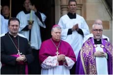 Ärkebiskopen av Sydney, Anthony Fisher (i mitten) och andra präster väntar på ankomsten av kardinal George Pells kista i St Mary's Cathedral, Sydney, Australien, den 1 februari 2023.